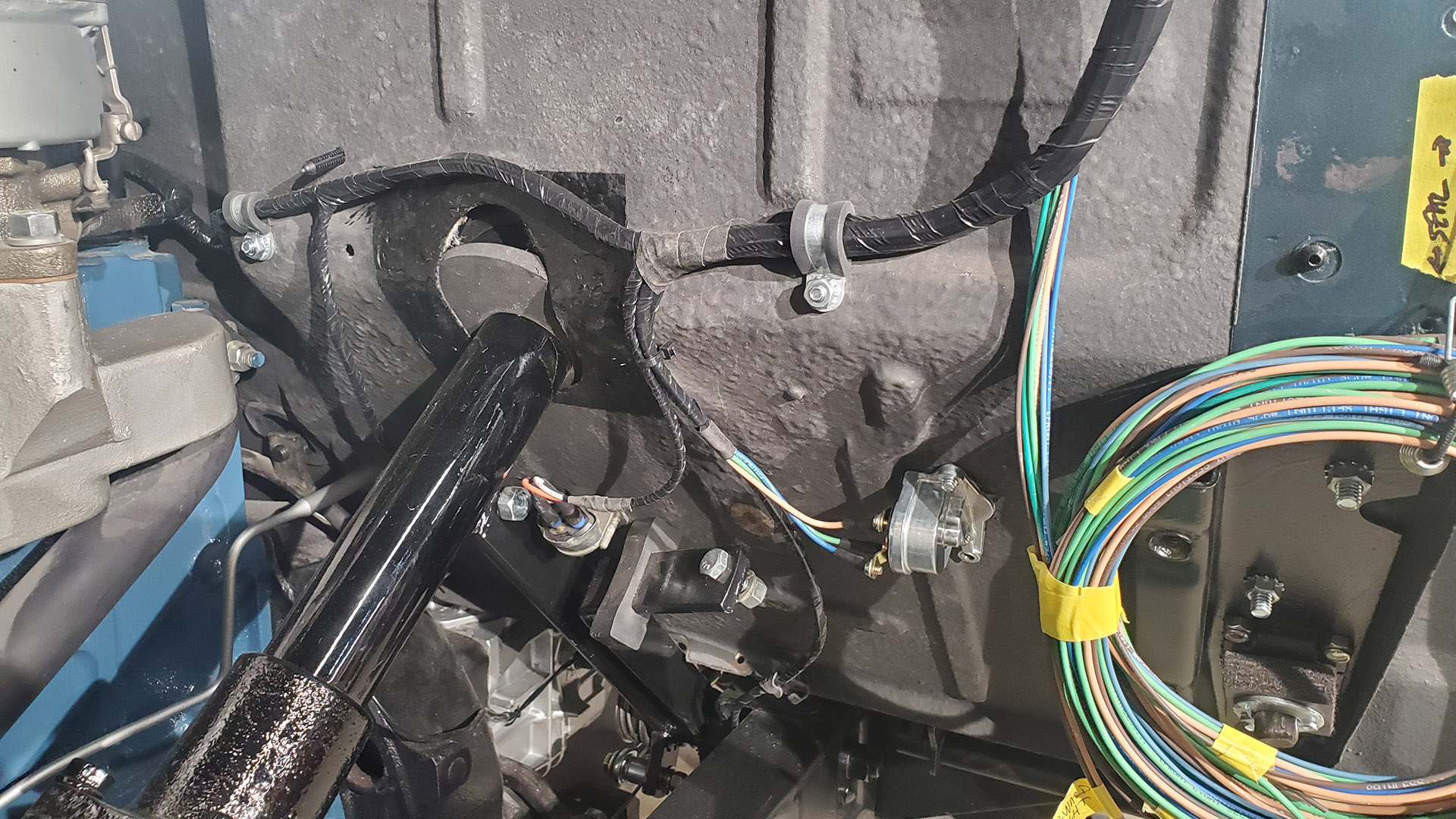 A small group of wires are rounted to the rear and other branches connect to the dimmer switch, brake light switch, and oil pressure sender (off camera). The bundle of unwrapped wires will get routed to the front lighting once the front clip is reinstalled.