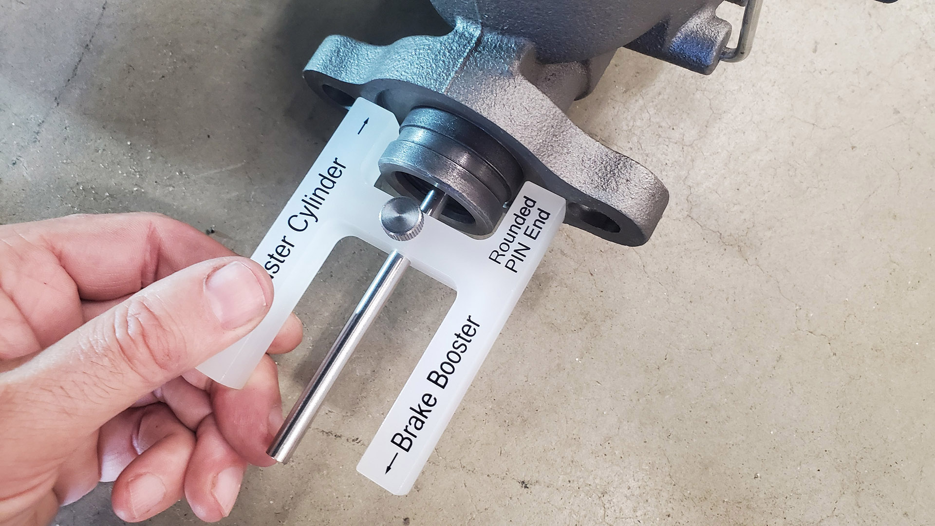 A brake booster adjustment tool is used to measure the length of the booster push rod. First, the depth of the piston hole is checked in the master and the rod locked in place.