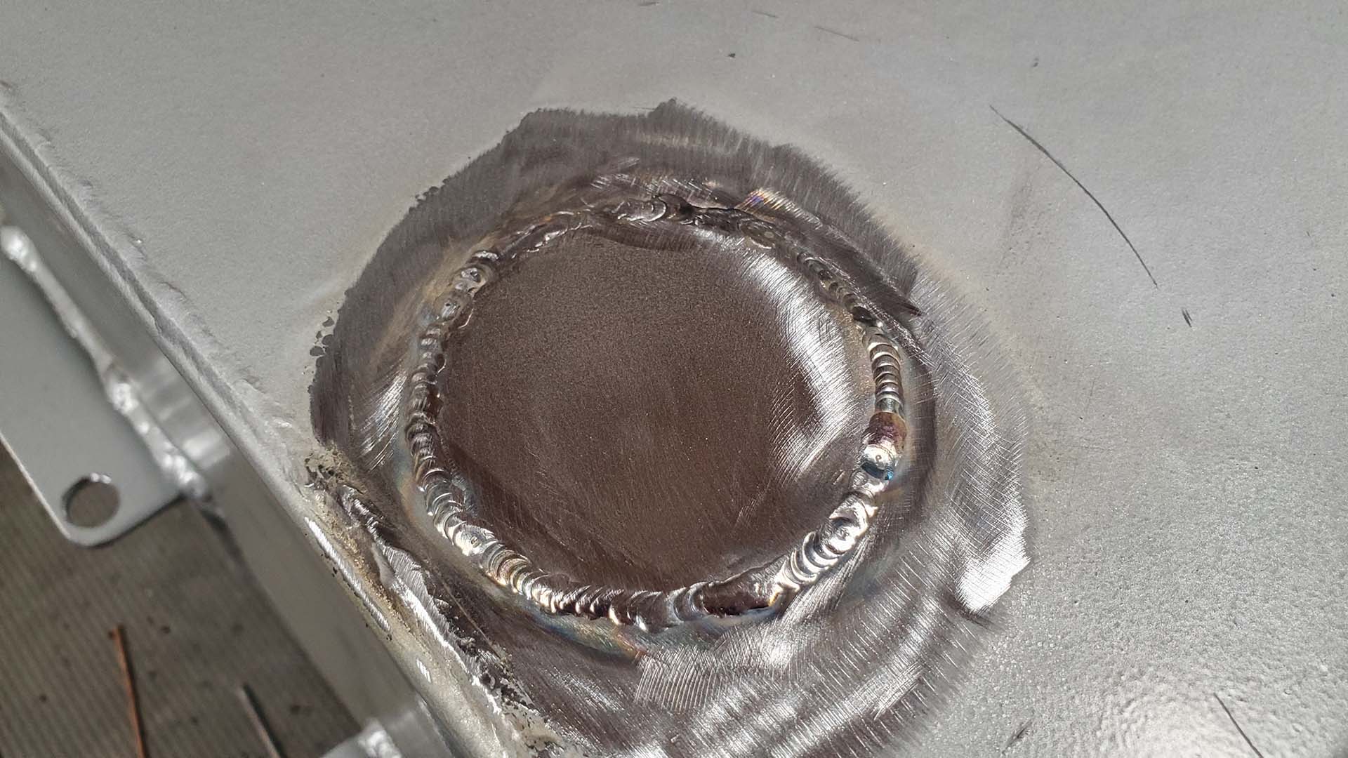 Some silver paint will touch up our welded patch and prevent rust.