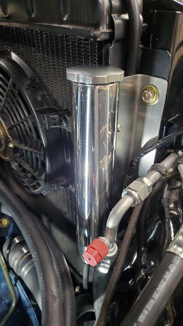 I made a bracket from a scrap of stainless angle I've had sitting on the shelf for years. The stainless steel coolant recovery tank is compact and mounted next to the radiator. Looks good!
